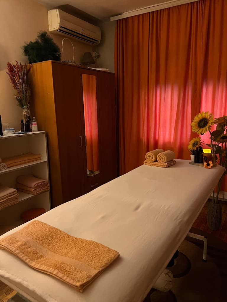 Prostor za masažu sa stolom, peškirima i prijatnim enterijerom u salonu Sunshine